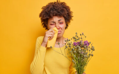 Een meisje dat lijdt aan hooikoorts met rode ogen en een loopneus met een gele achtergrond