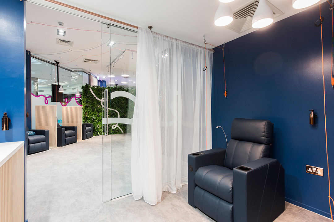 Private IV room with white curtain, blue recliner chair and blue wall